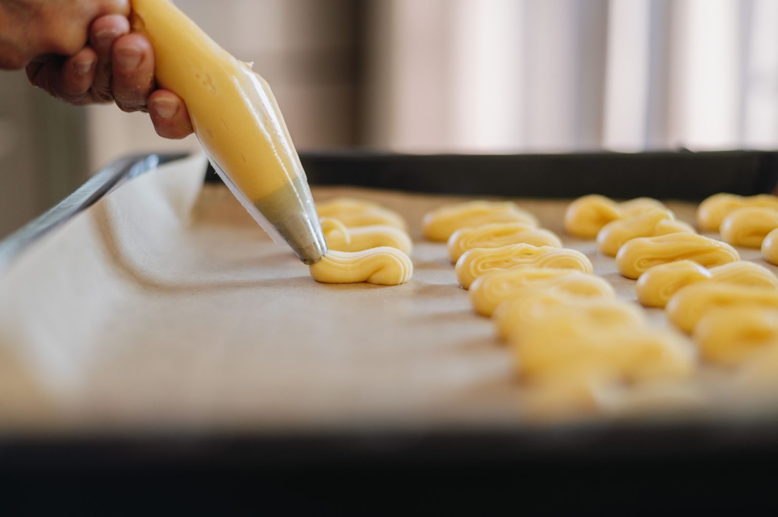 Pâte à choux Pâte à choux dressée à la poche sur une plaque de cuisson